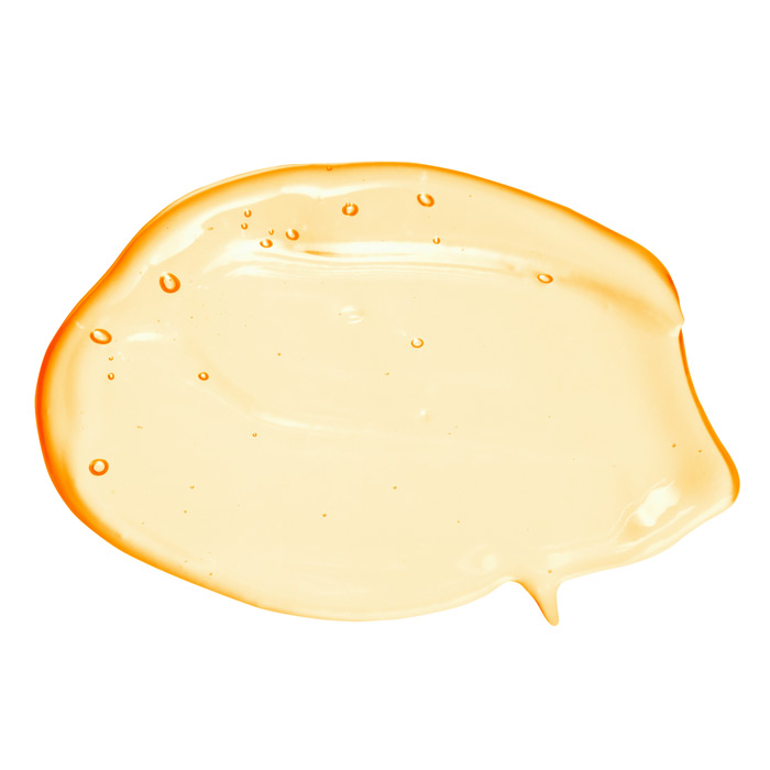 Smear of yellow vitamin c serum on white background