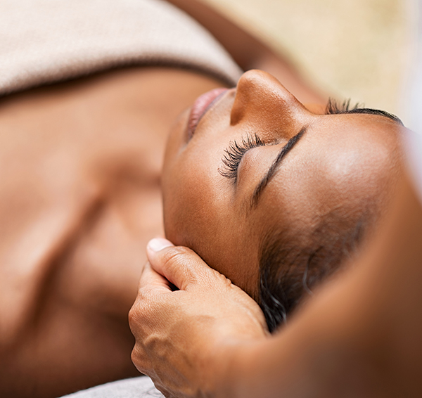 Dark toned woman receiving facial