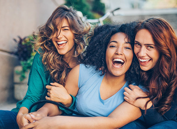 Group of three women smiling and laughing together