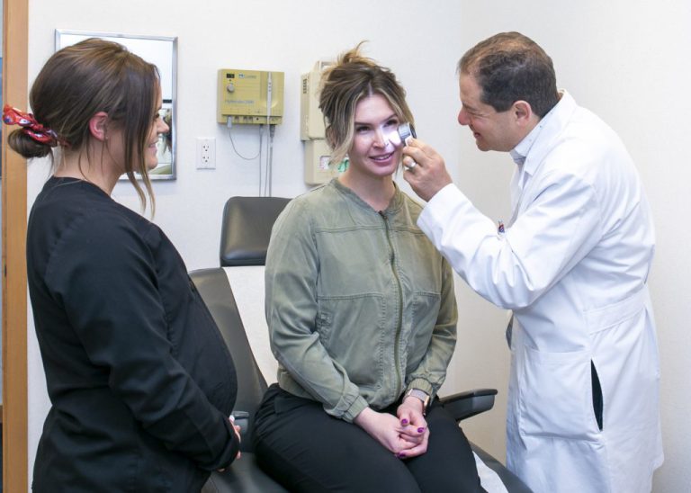 Dr. Schlessinger doing a skin check on a female patient